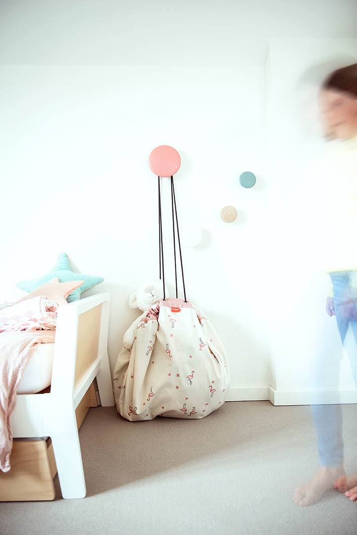 blur picture of walk in a park storage bag, hanging on wall, next to white bed