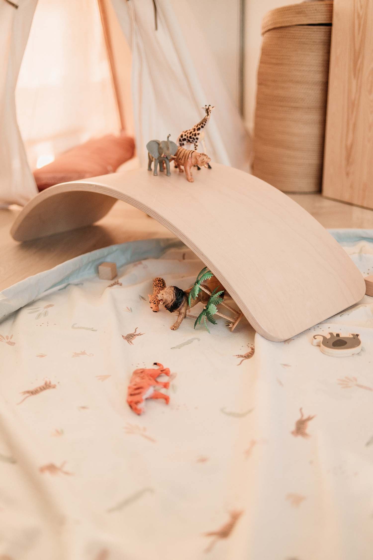 close picture of toystorage bag, jungle print, wooden brigde over mat, lots of animal toys