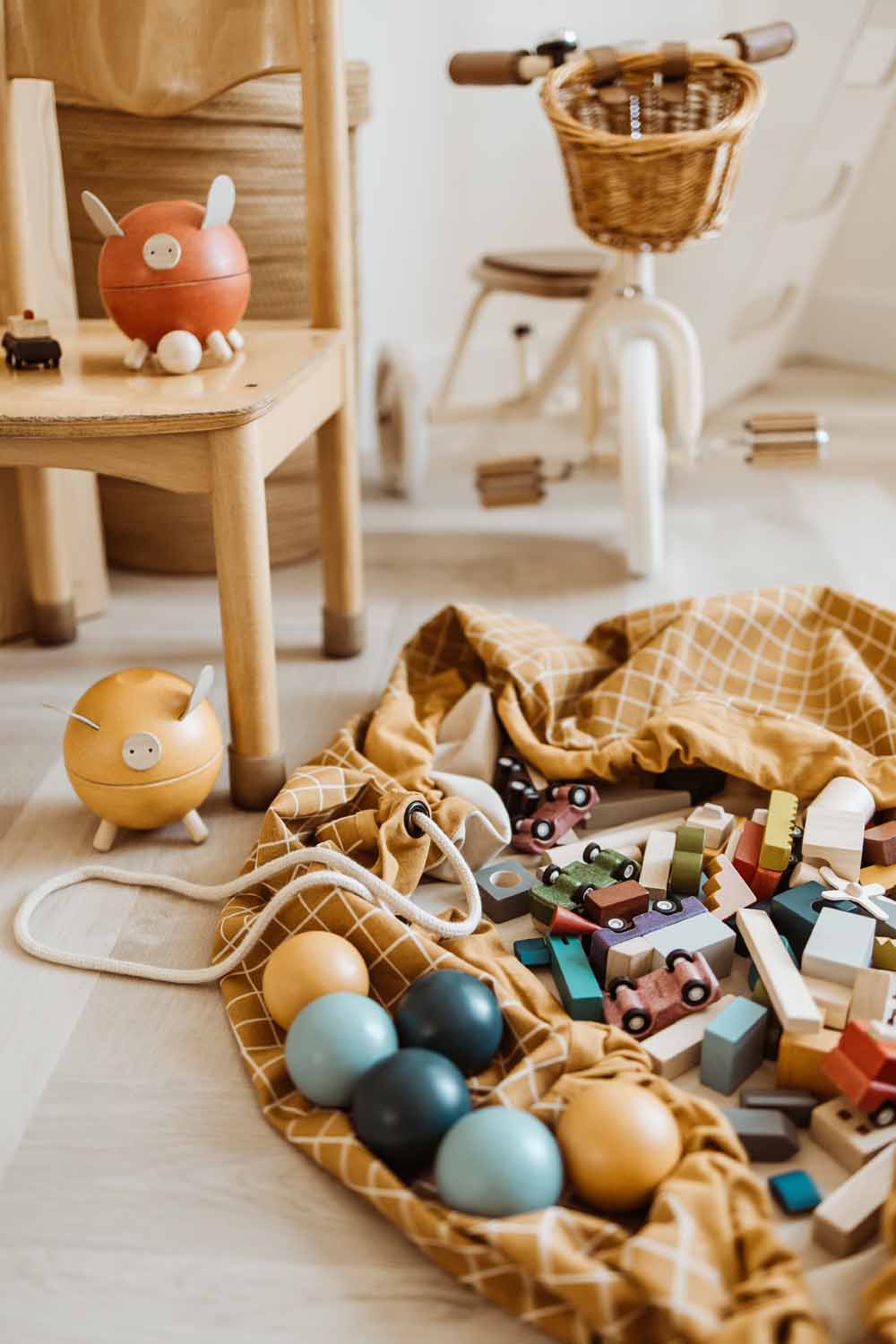 organic grid mustard storage bag, open bag filled with wooden toys, tricycle, wooden chair