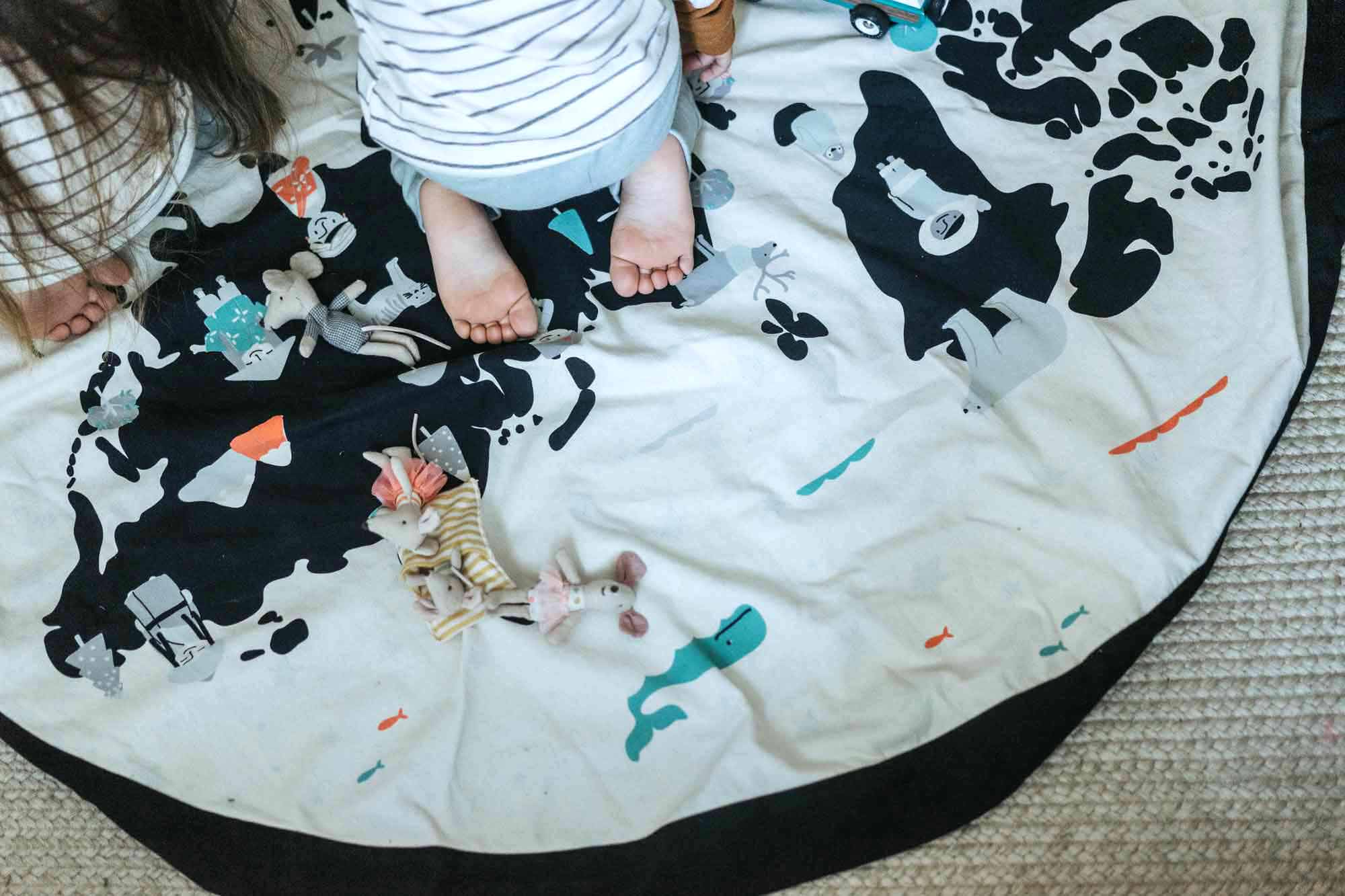 worldmap/stars storage bag, children sitting on mat, lots of toys