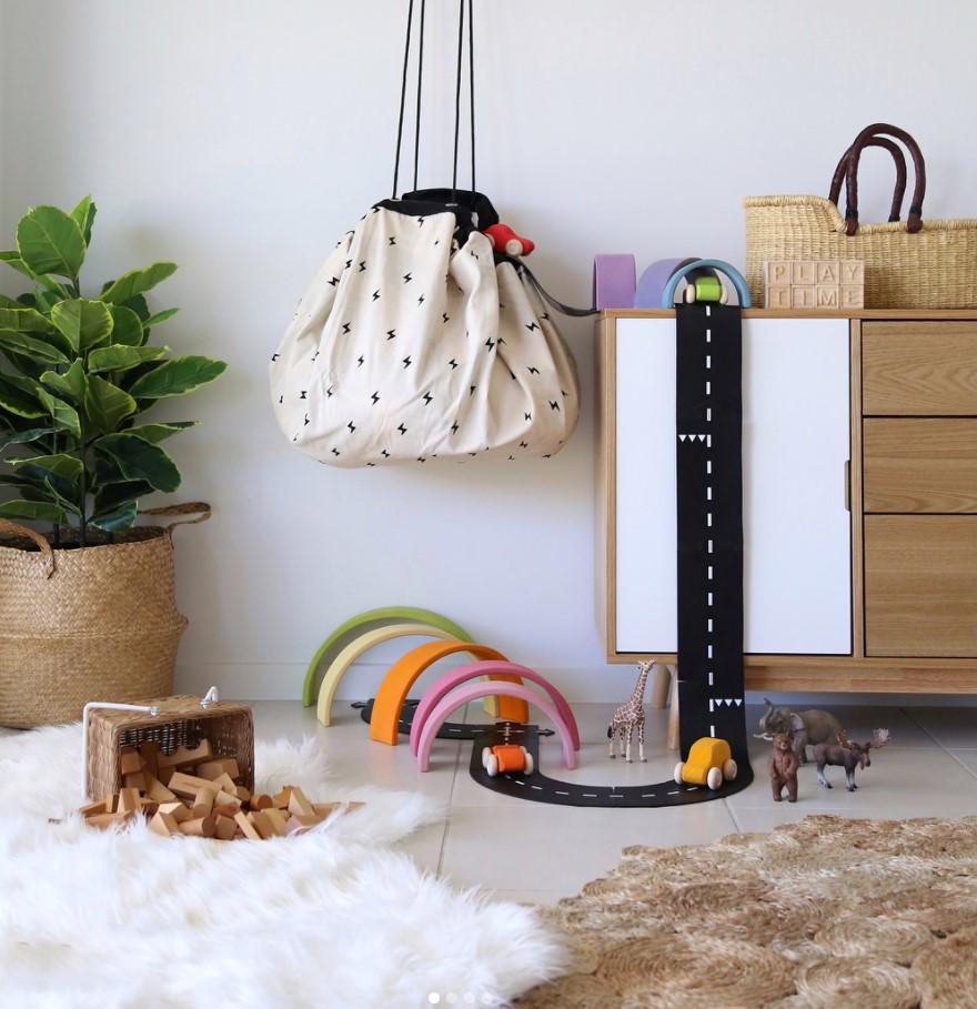 Roadmap/Thunderbolt Storage Bag and play mat, bag hanging on wall, next to closer and plant, lots of wooden toys