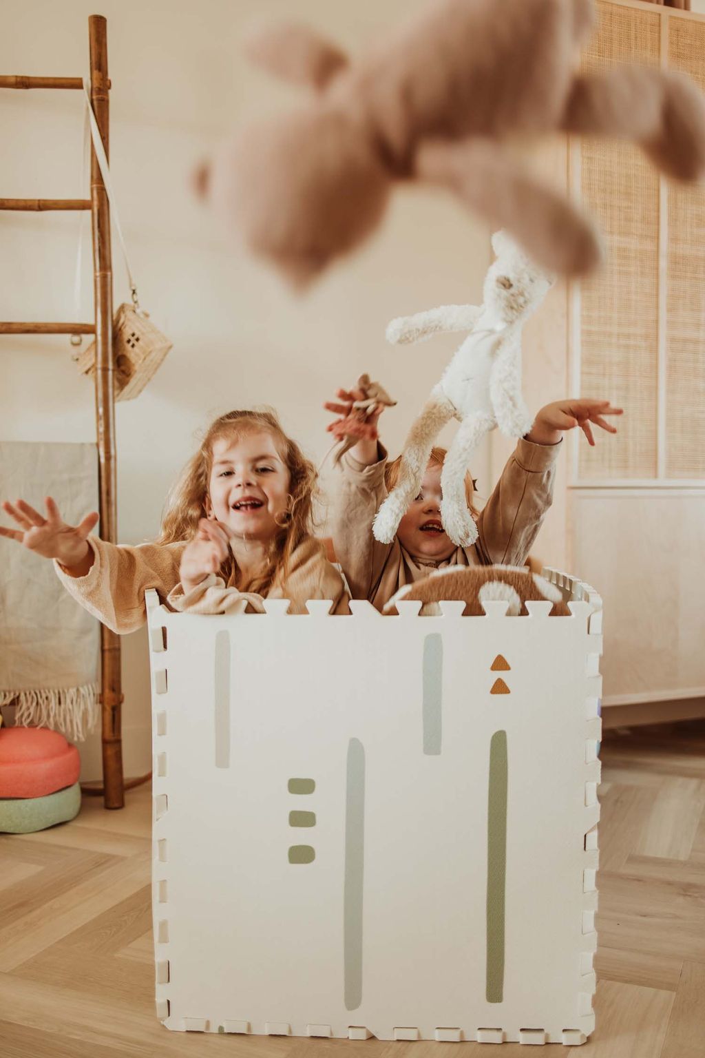 EEVAA farm puzzlemat, children are sitting in the box while throwing out cuddles