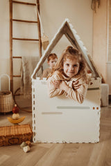 EEVAA farm puzzlemat made into a playhouse, print of icons and stripes, child is sitting in the playhouse