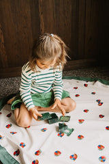 snails toy storage bag and playmat, child is sitting on the mat while playing