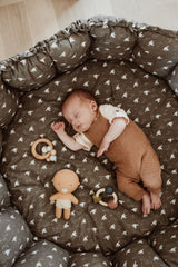 bloom birds babymat, crib, raised edges, little baby is sleeping in the crib, wooden toys and doll