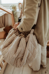 soft stripes blue organic babymat, person is carrying the bag with the shoulder strap