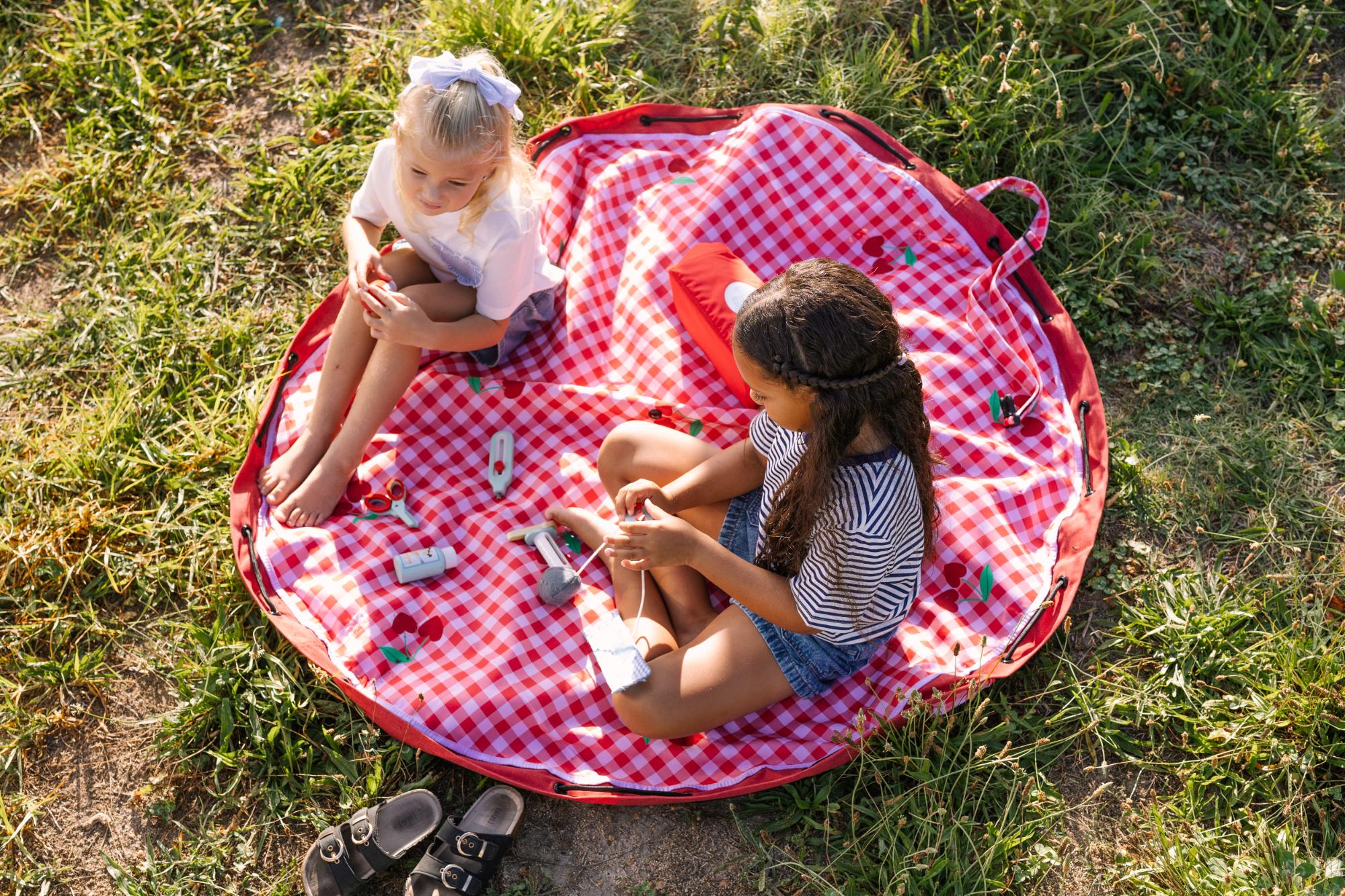 Pic nic outdoor storage bag, children are playing on the mat outside with doctors toys