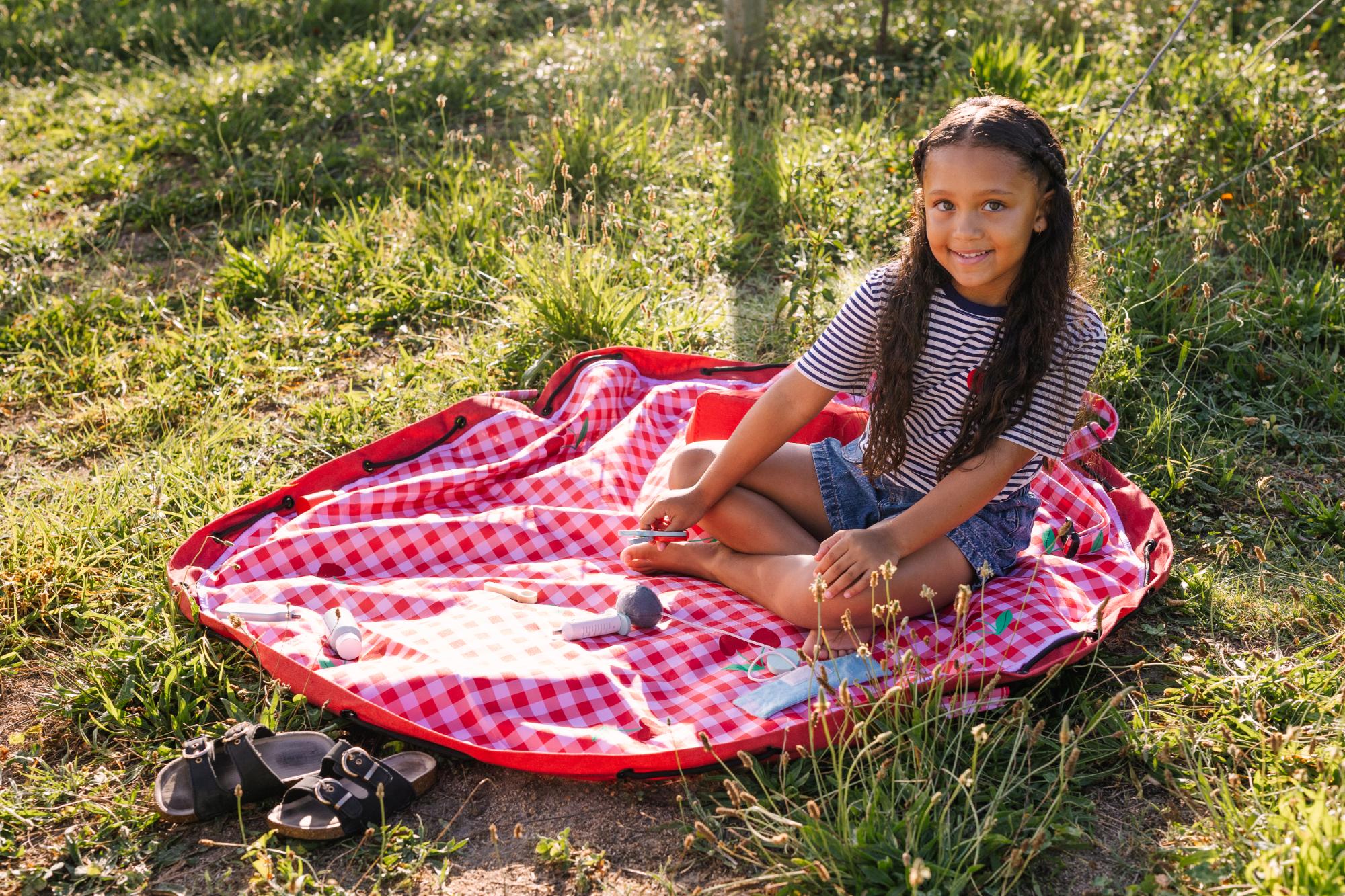 Pic nic outdoor storage bag, child is playing on the mat, outside