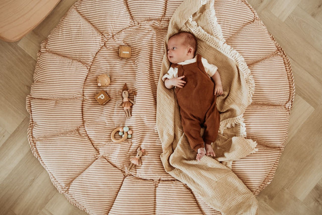bloom stripes brown babymat, open, baby is lying on the mat, looking at wooden toys