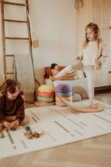 EEVAA farm puzzlemat, child is playing with wooden blocks while other child is standing on a wooden swing board in kidsroom