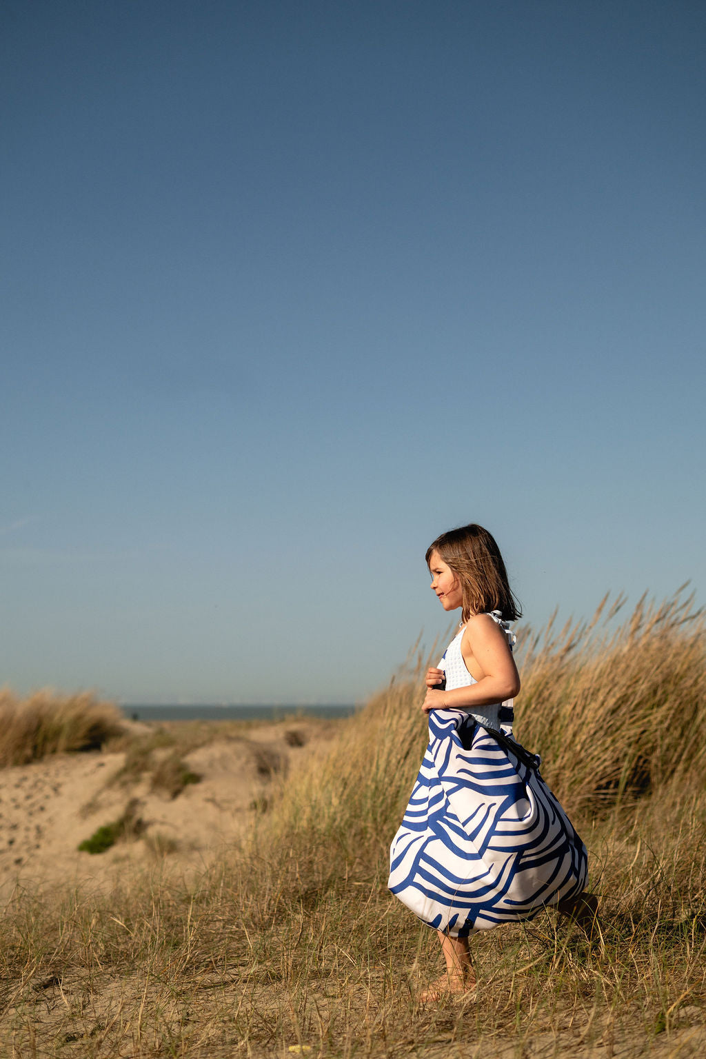 Pirate outdoor storage bag, child is carrying the closed bag on its shoulder, standing at the beach