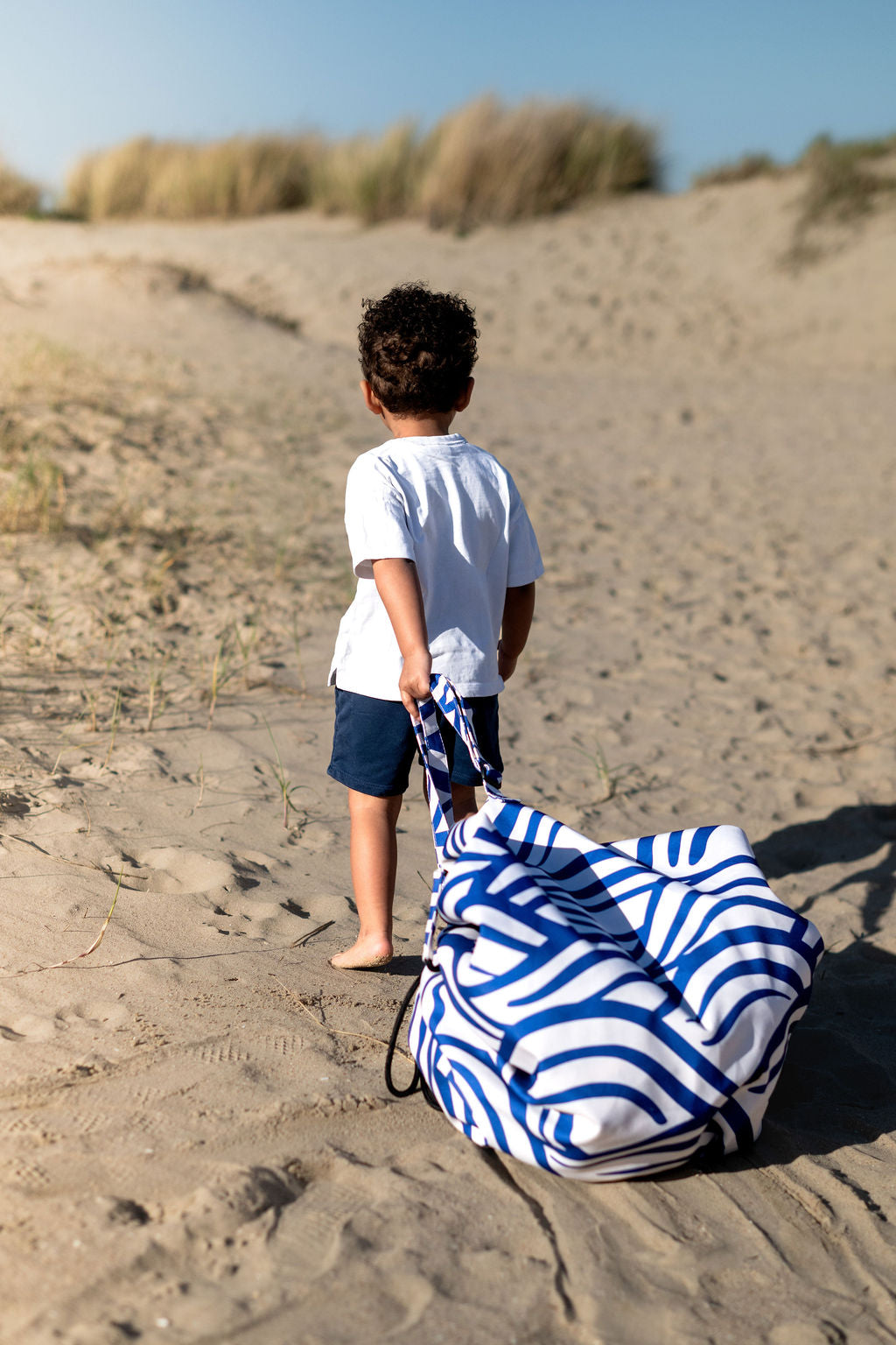 Pirate outdoor storage bag, child is carrying the closed bag by its shoulderstrap
