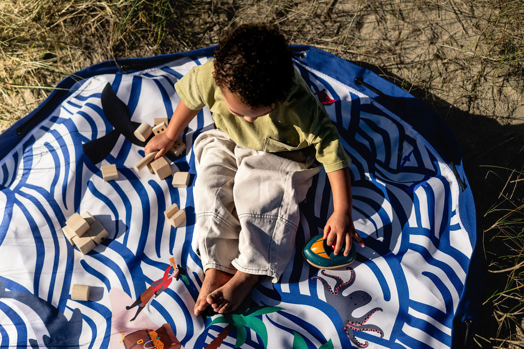 Pirate outdoor storage bag, child is playing with wooden toys, sitting on the mat