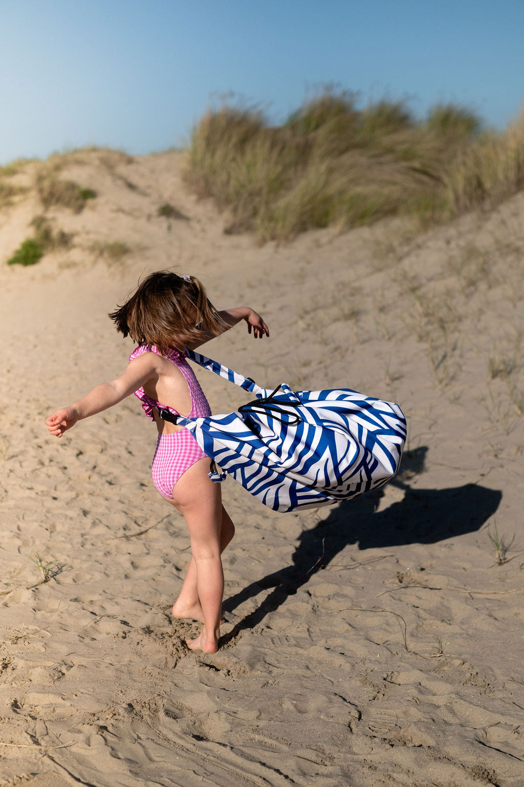 Pirate outdoor storage bag, child is carrying the bag around its body while turning around