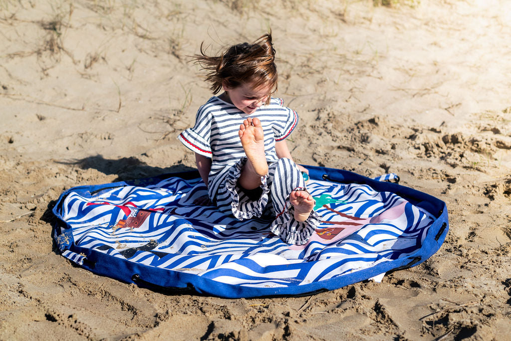 Pirate outdoor storage bag, child is sitting on the open mat in the sand