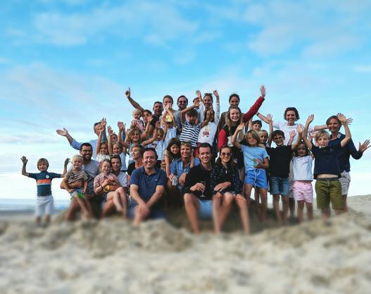 A group of people cheering and waving to the camera out of happiness.