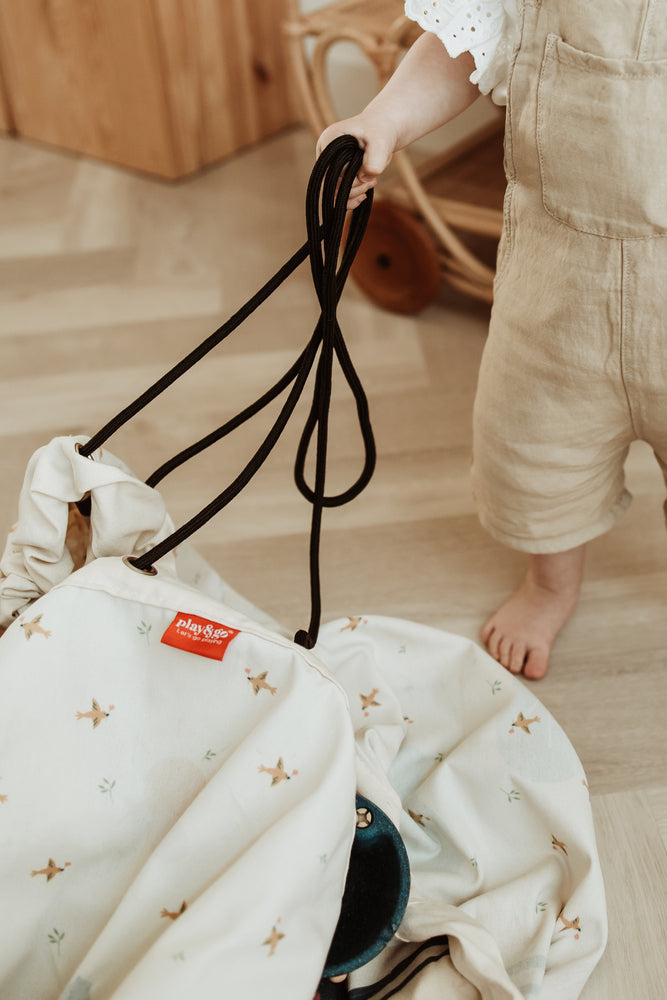 farm storage bag, child holding ropes of closed bag