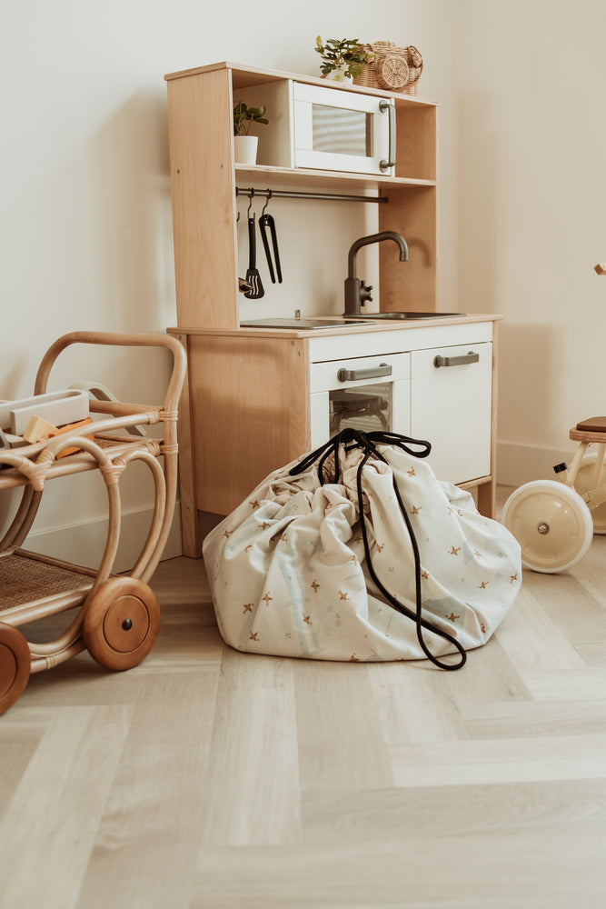farm storage bag, standing on floor, in kidsroom, next to wooden kitchen