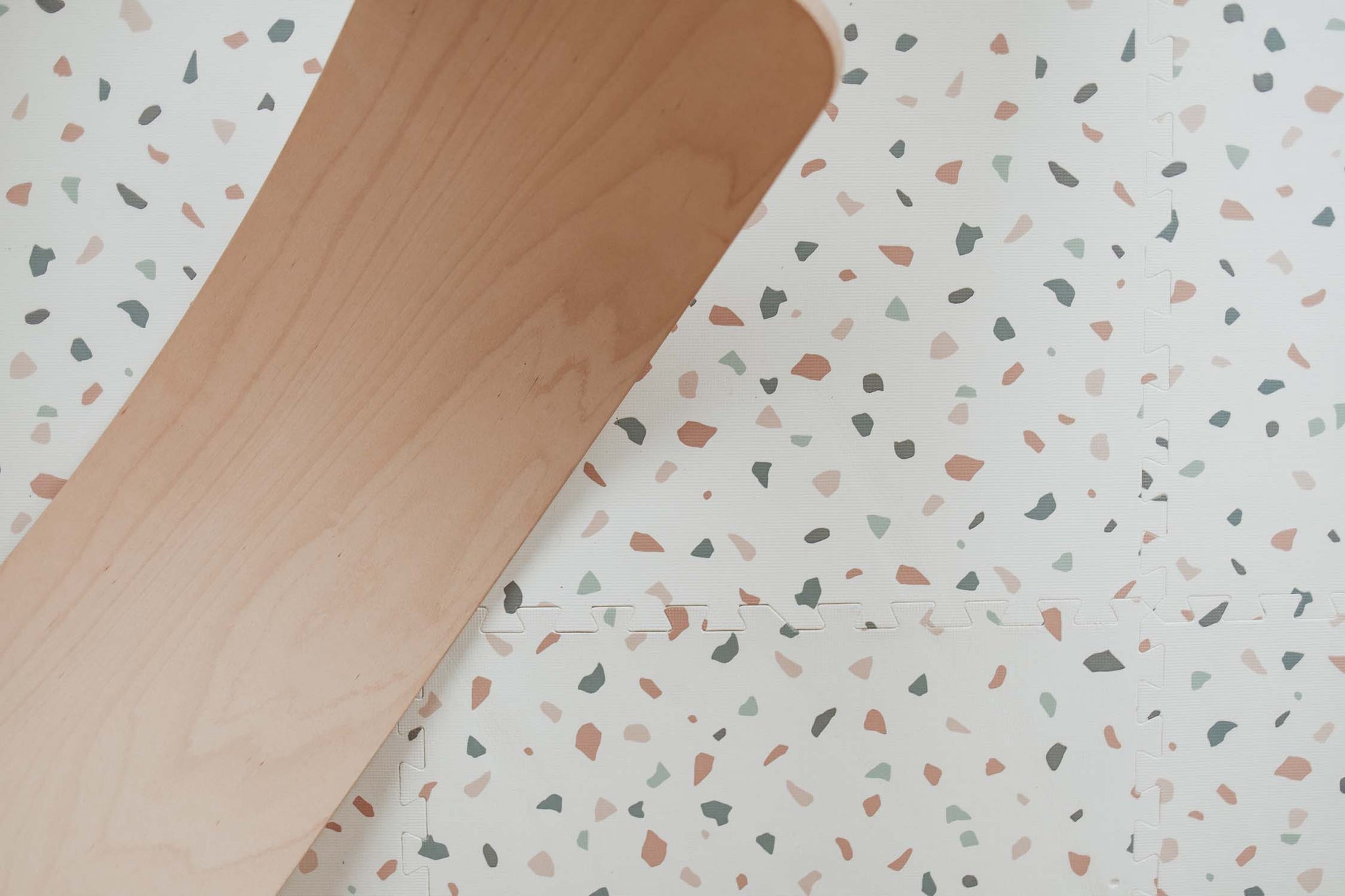 detail picture of terrazzo puzzlemat, wooden slide on top of the mat