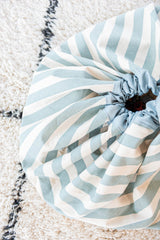 detail picture toy storage bag and play mat, green stripes, closed bag on white carpet